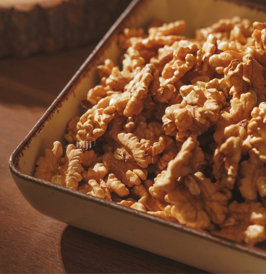 A tray of Chilean walnut kernels displayed on a wooden surface.